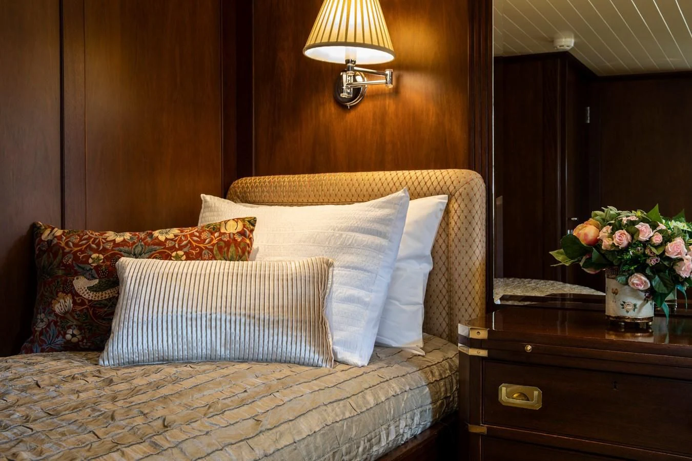 a bed with a flowered pillow aboard ODYSSEY III Yacht for Sale