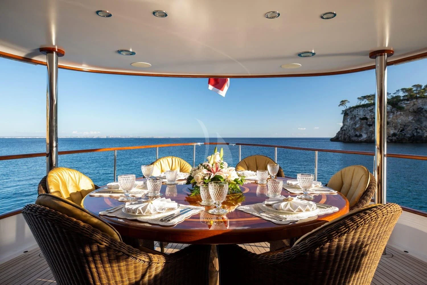 a table with chairs and a view of the ocean aboard ODYSSEY III Yacht for Sale