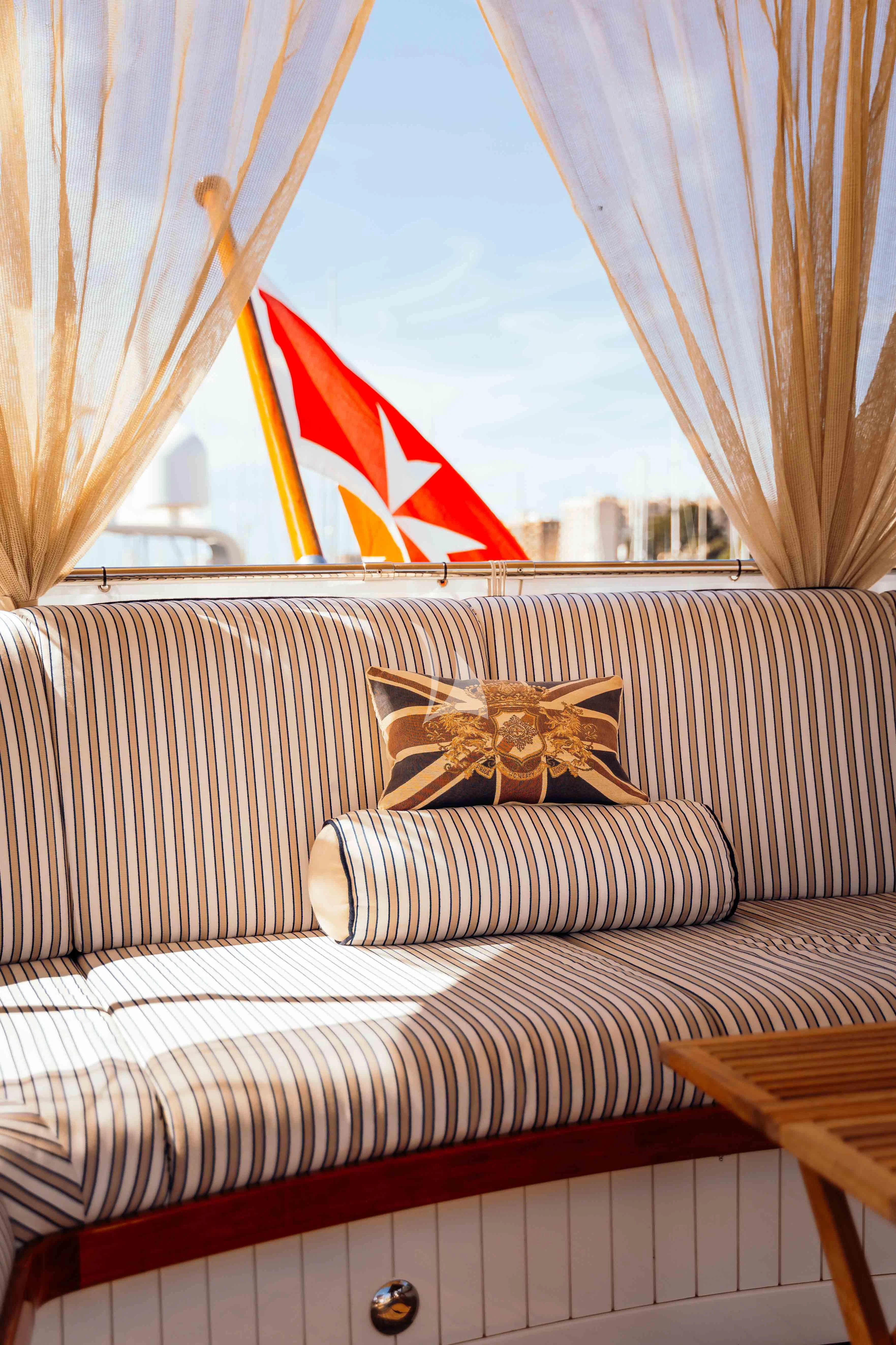 a flag on a couch aboard ODYSSEY III Yacht for Sale
