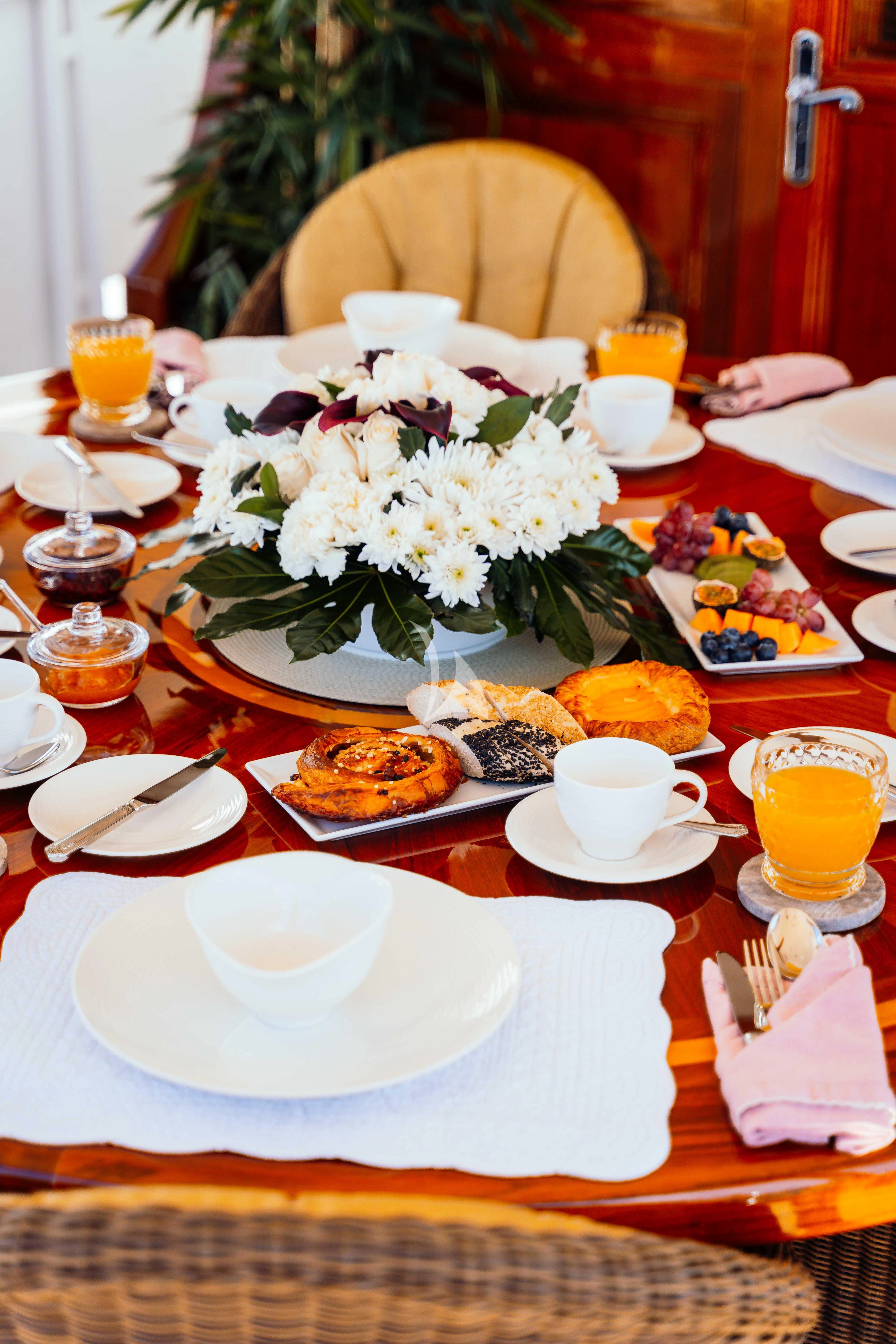 a table with plates and food on it aboard ODYSSEY III Yacht for Sale