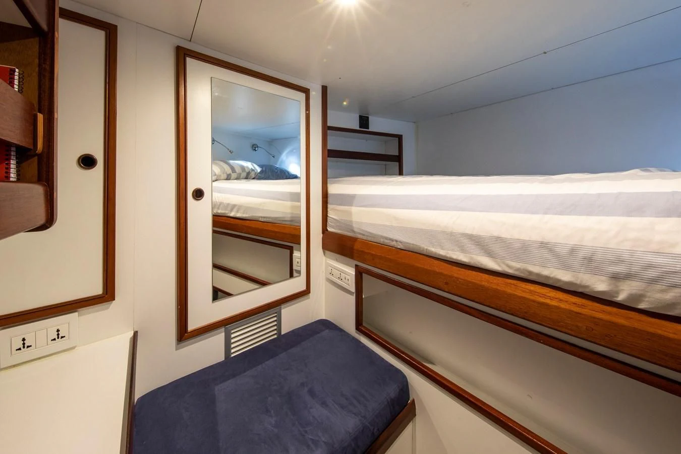 a bedroom with a bed and a mirror aboard ODYSSEY III Yacht for Sale