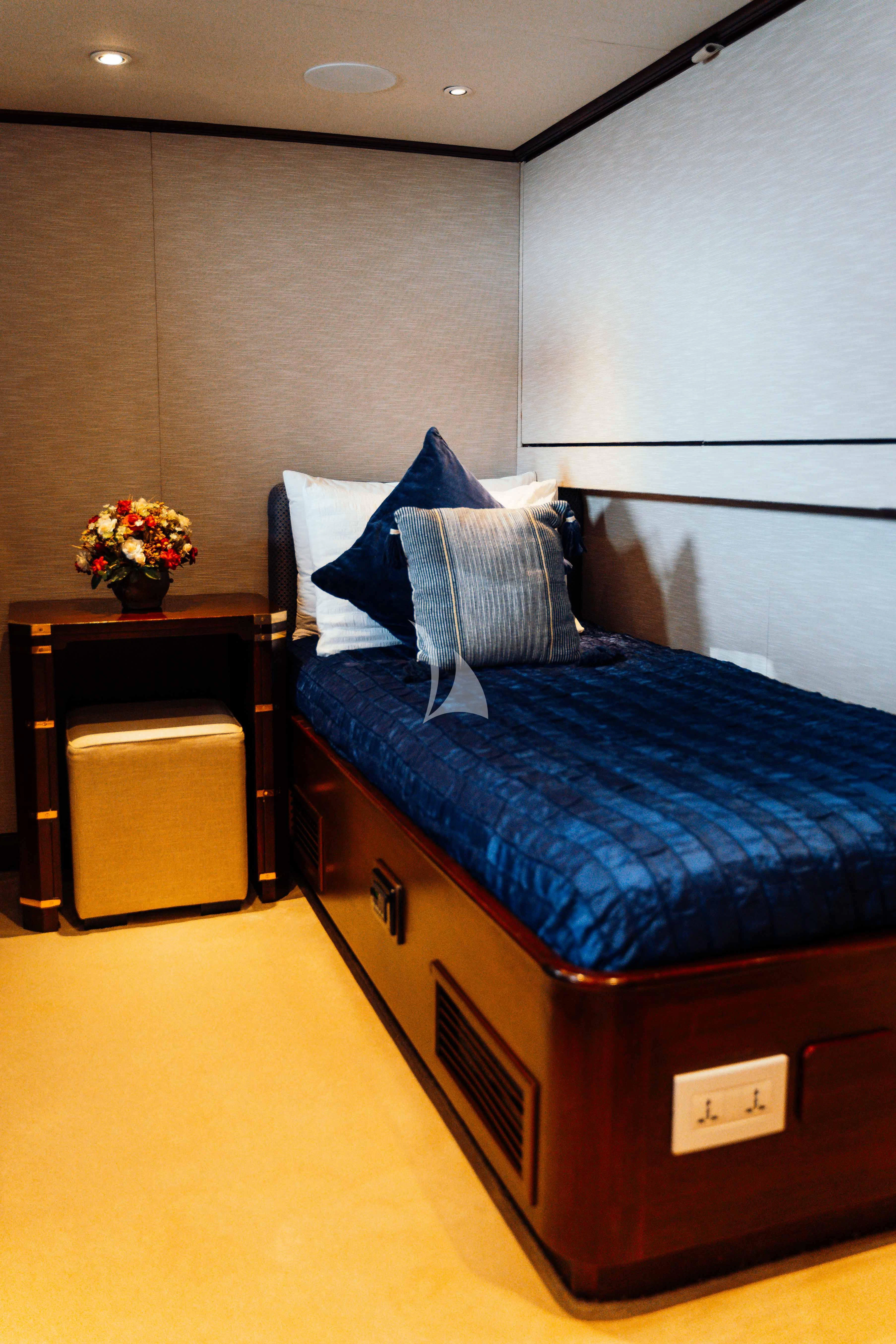 a bed with a blue comforter aboard ODYSSEY III Yacht for Sale