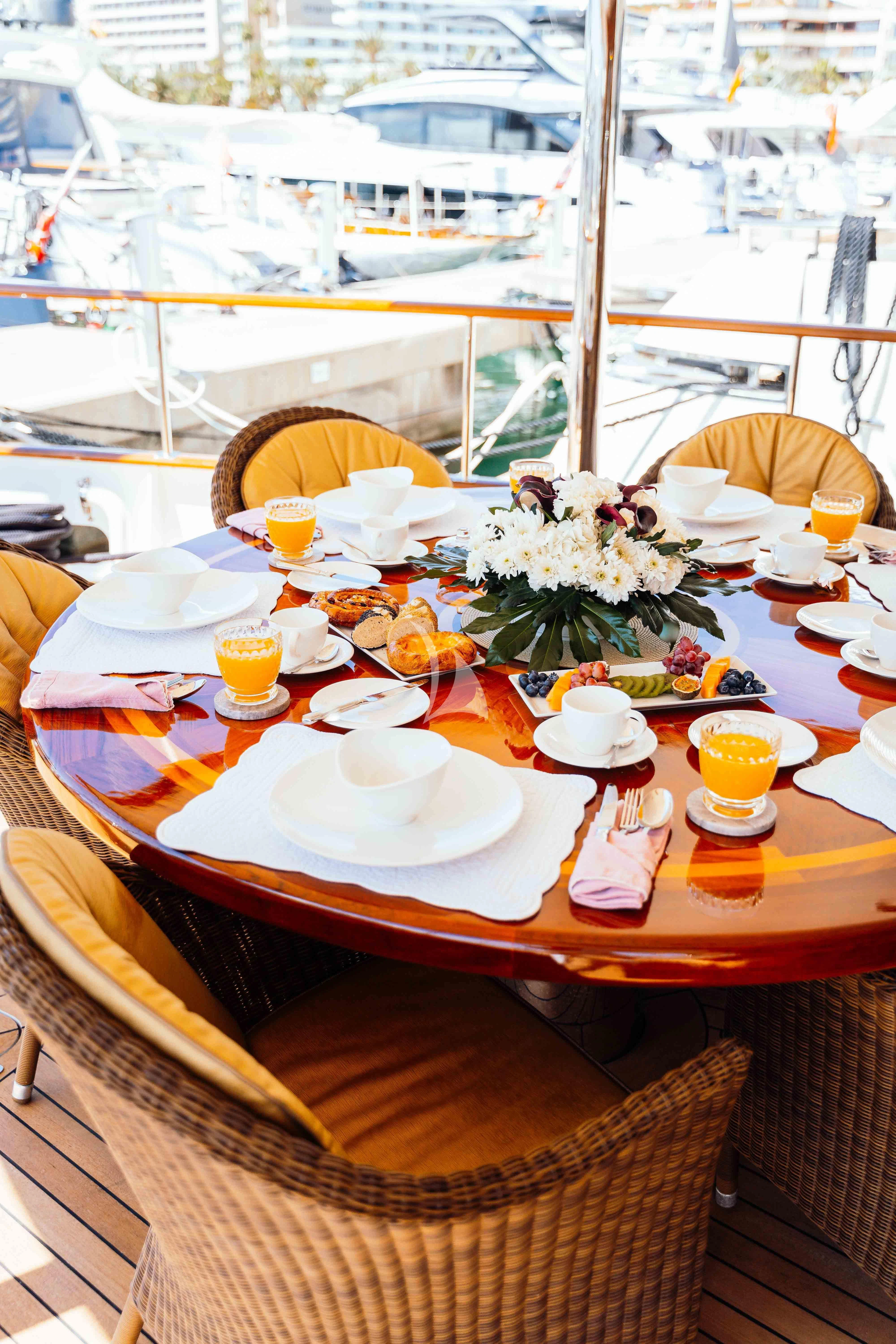 a table with food and drinks on it aboard ODYSSEY III Yacht for Sale