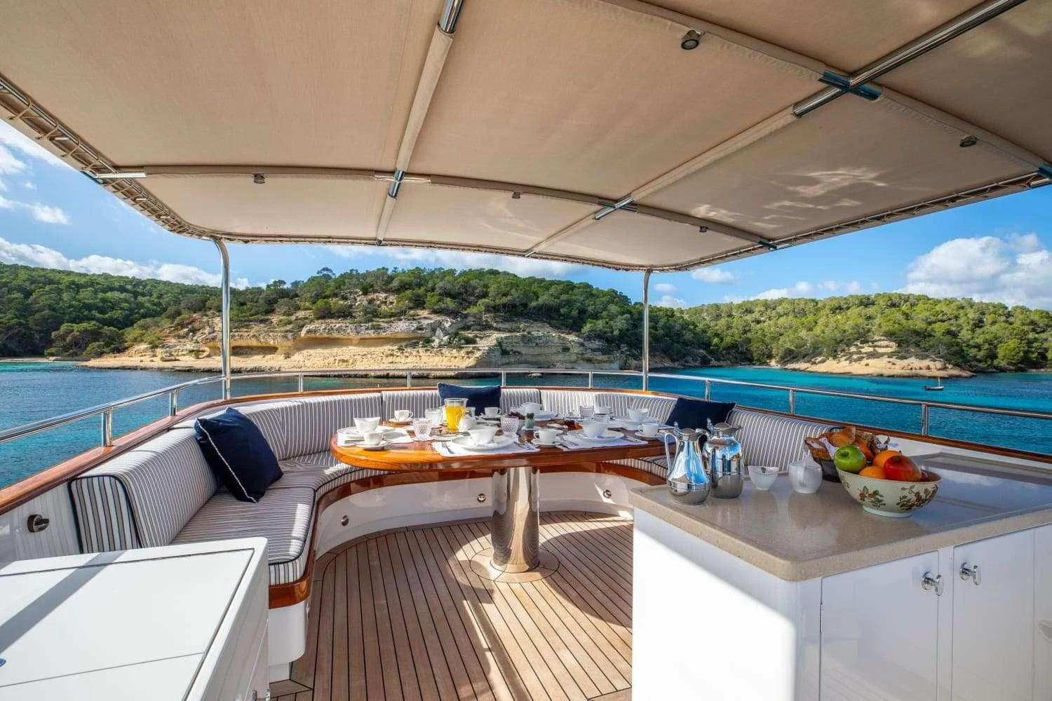 a table and chairs on a deck aboard ODYSSEY III Yacht for Sale