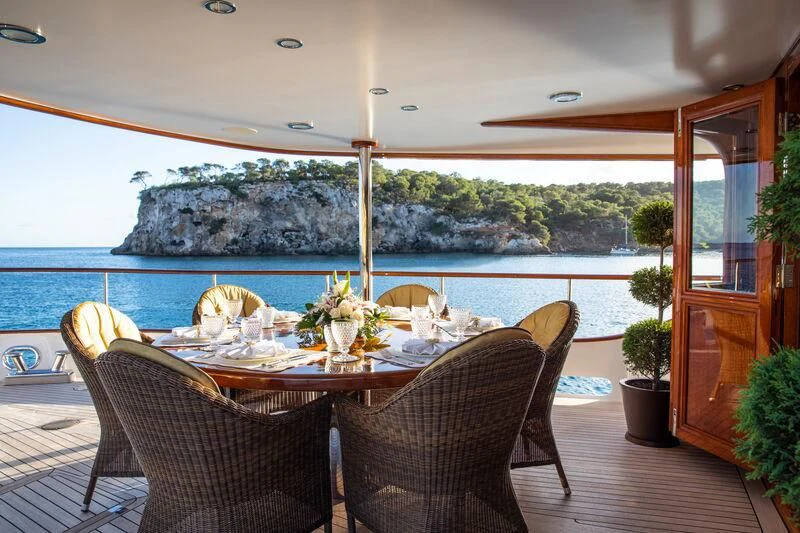 a table with chairs and plants on it aboard ODYSSEY III Yacht for Sale