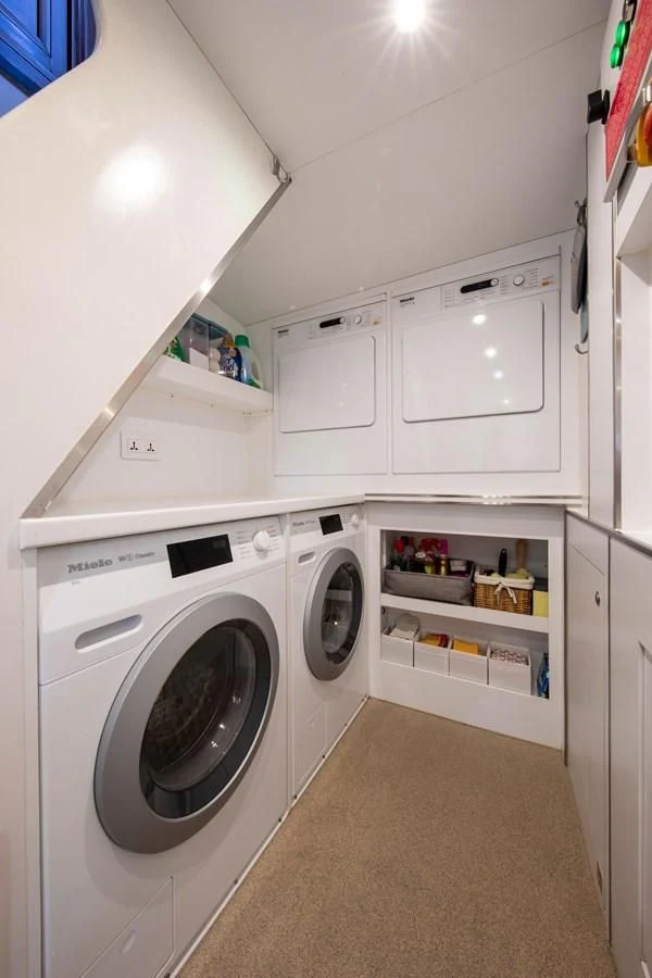 a laundry room with a washer and dryer aboard ODYSSEY III Yacht for Sale