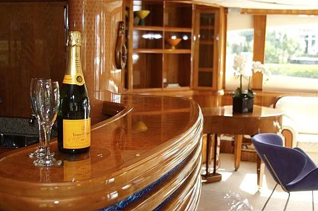 a wine bottle and a glass on a table aboard AZURE II Yacht for Sale