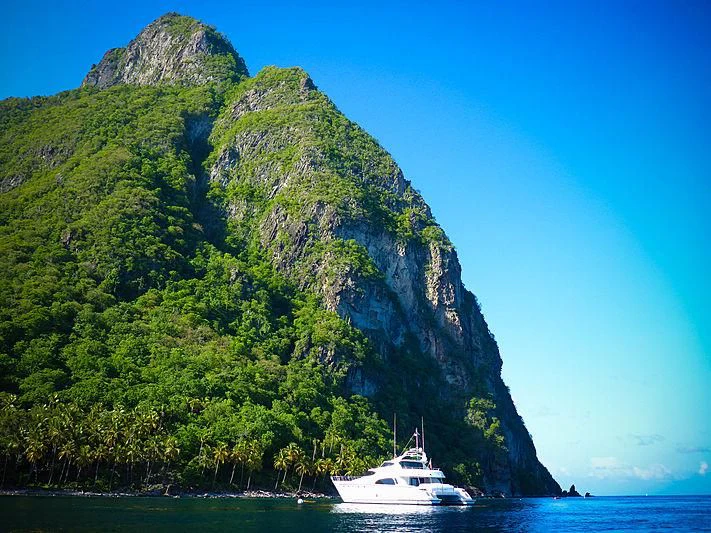 a boat in the water by a cliff aboard AZURE II Yacht for Sale