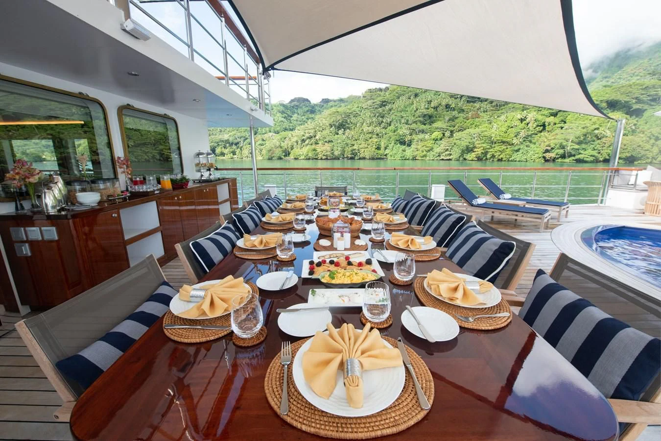 a dining table with plates and food aboard LATITUDE Yacht for Sale