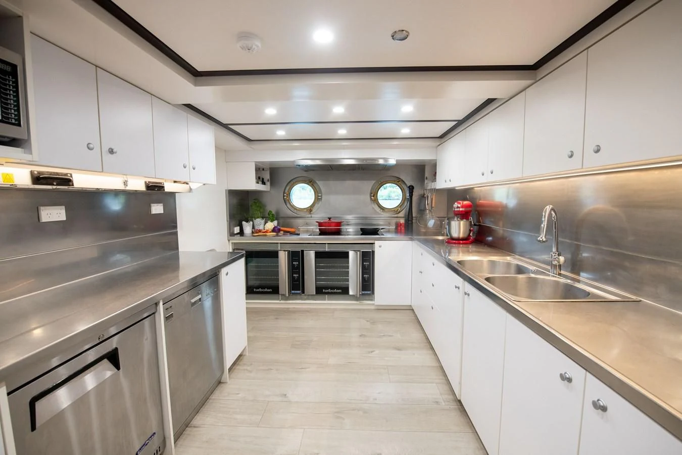 a kitchen with white cabinets aboard LATITUDE Yacht for Sale