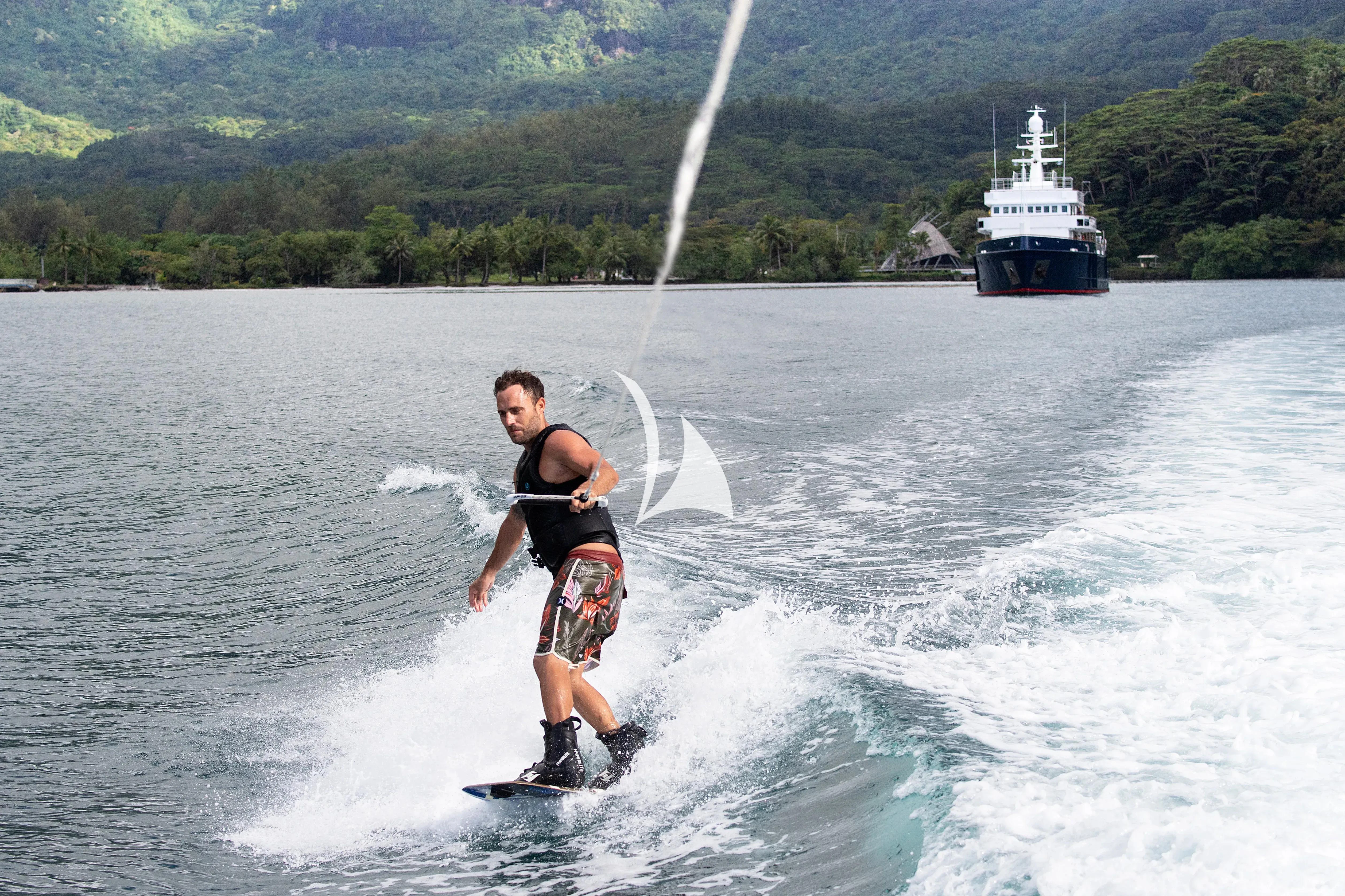 a man water skiing with a boat behind him aboard LATITUDE Yacht for Sale