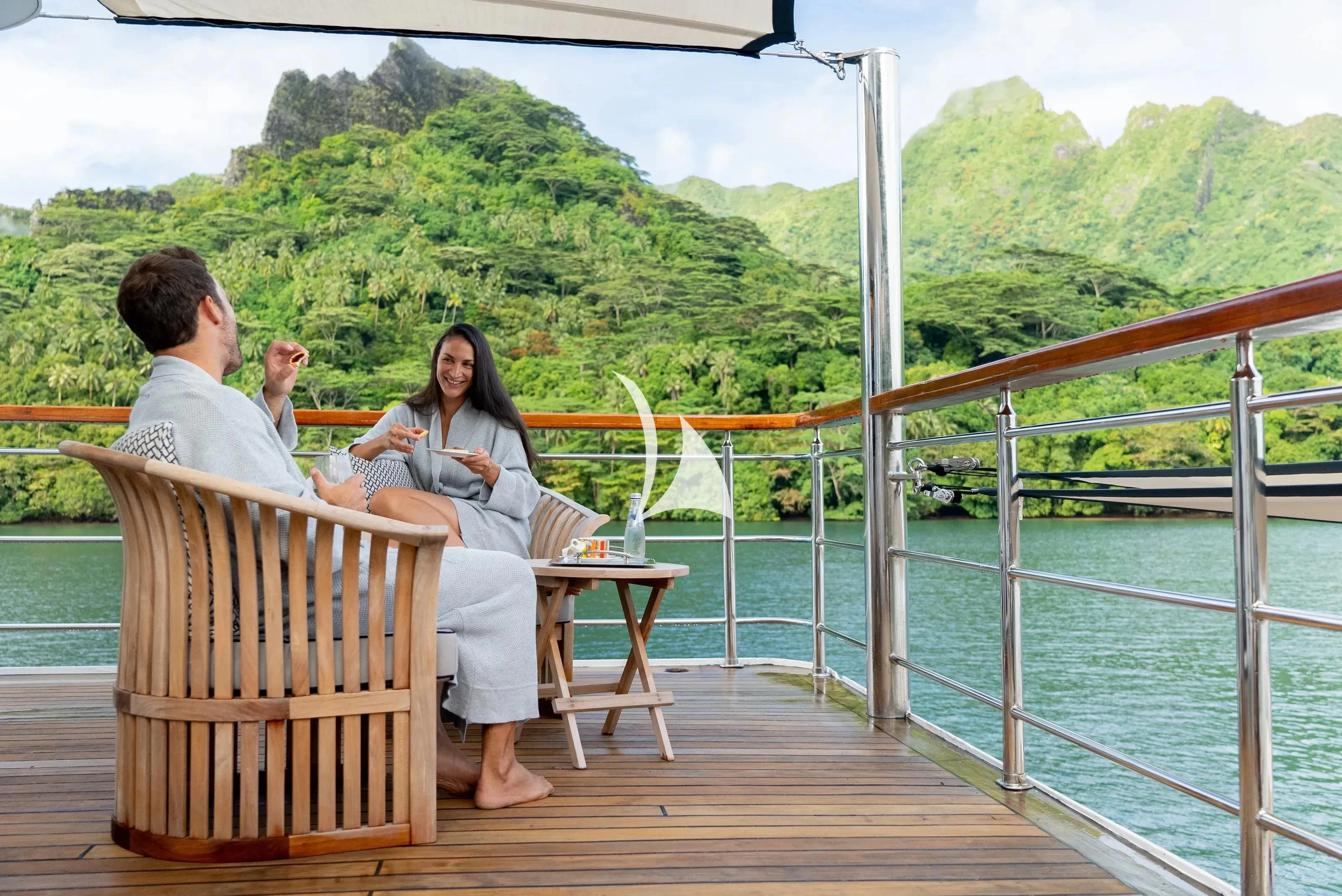 a group of people sitting on a wooden deck on a boat aboard LATITUDE Yacht for Sale