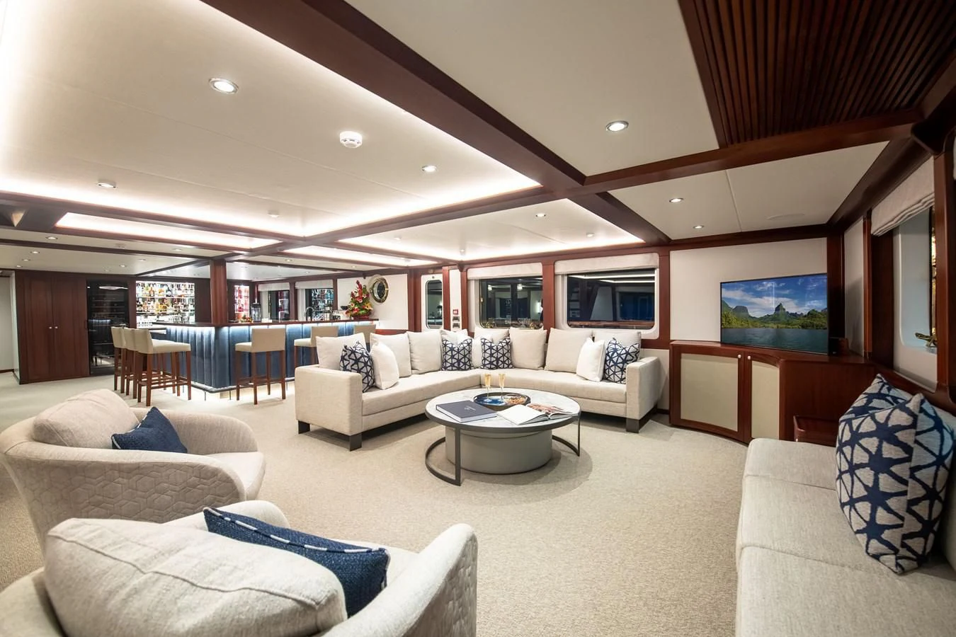 a living room with a large white sofa and a large wood table aboard LATITUDE Yacht for Sale