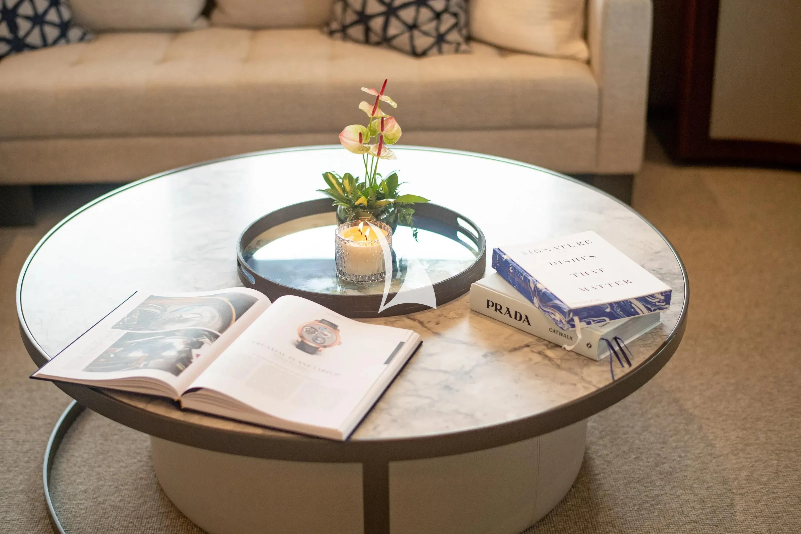 a coffee table with a tray of books and a plant on it aboard LATITUDE Yacht for Sale