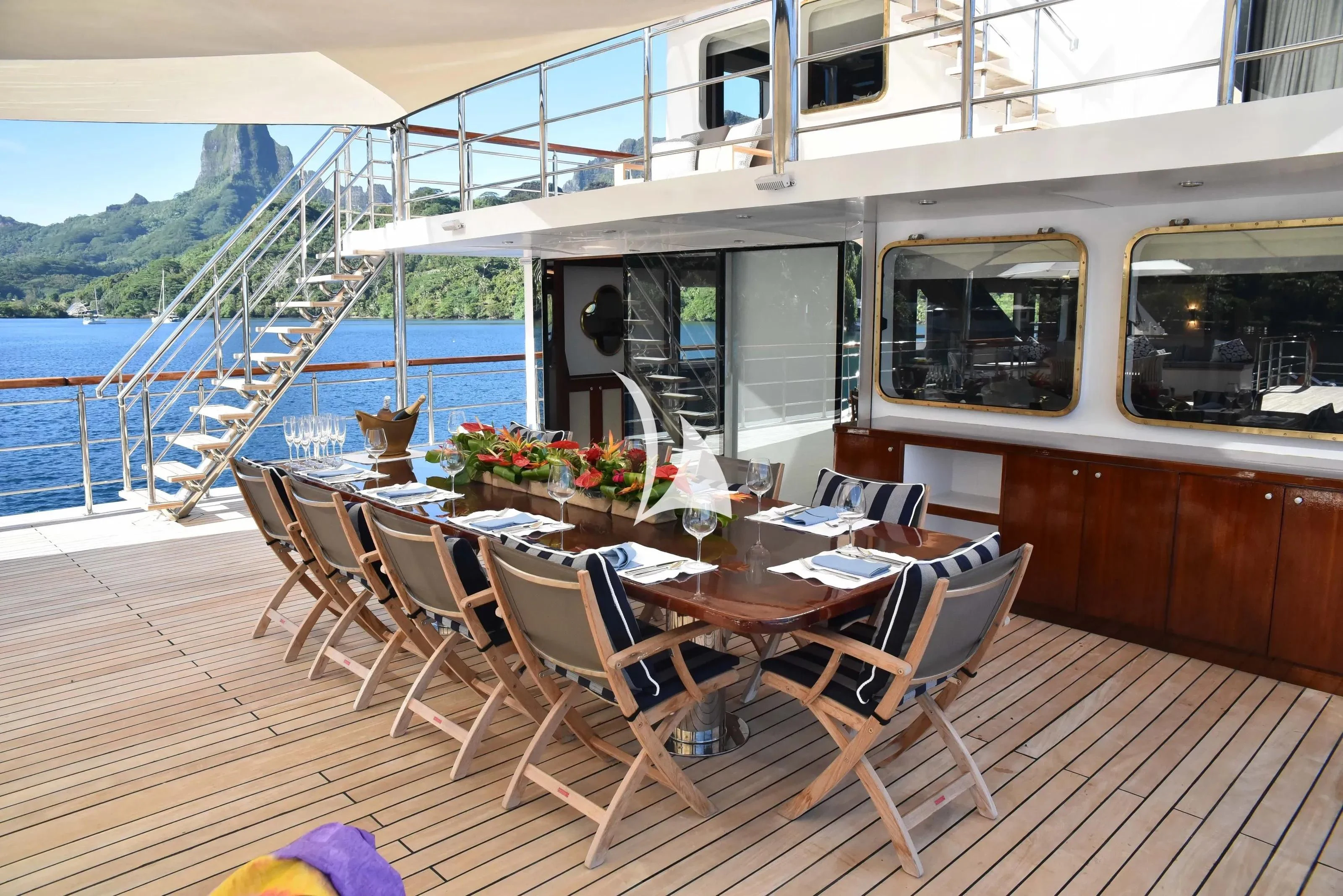 a deck with tables and chairs on it aboard LATITUDE Yacht for Sale