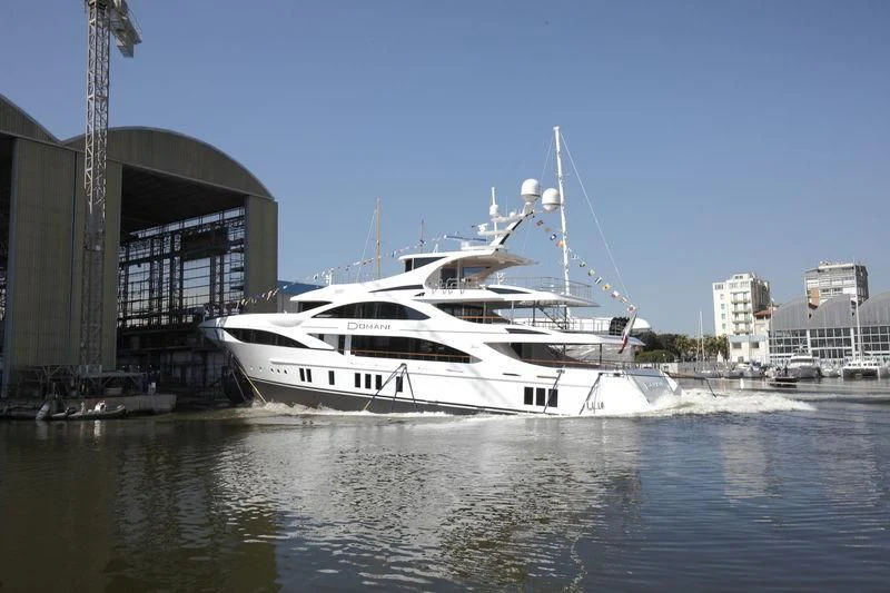 a white yacht docked at a pier aboard DOMANI Yacht for Sale