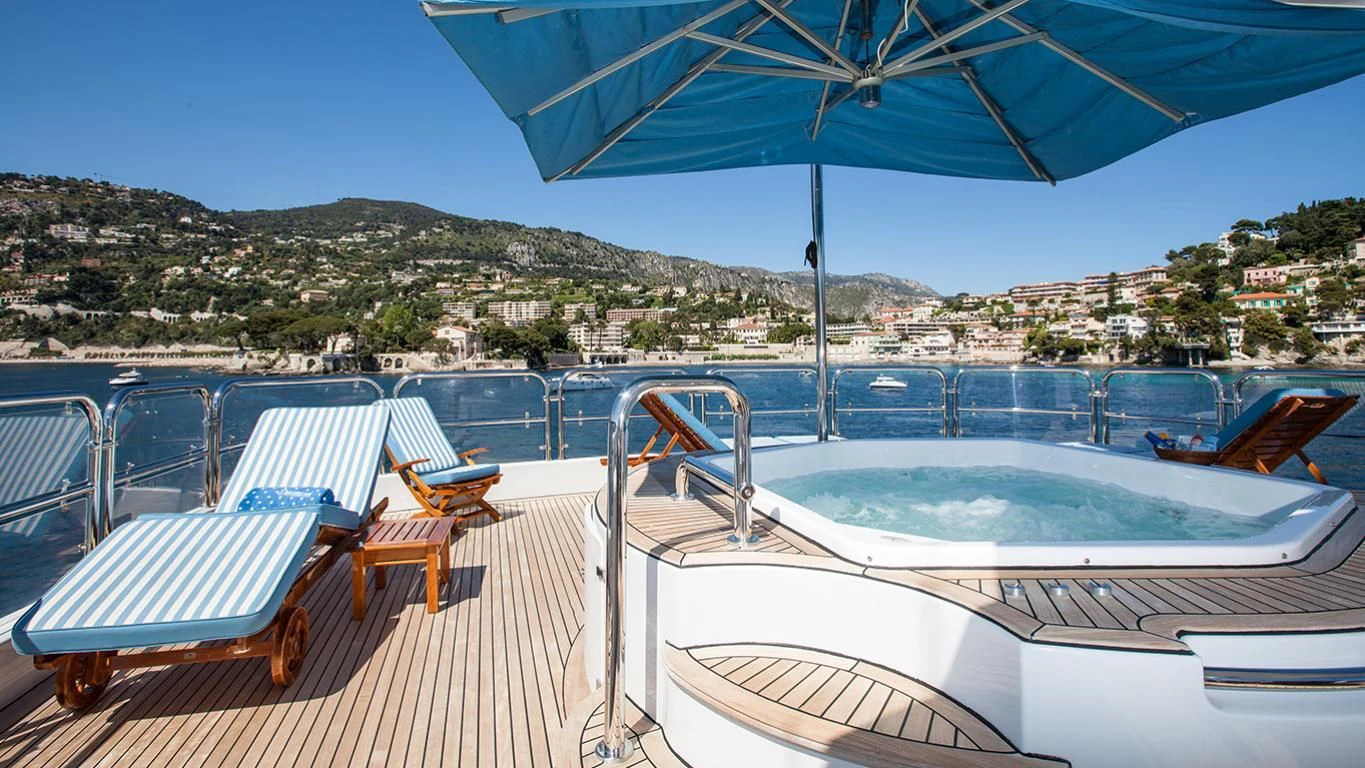 a deck with chairs and tables on it aboard DOMANI Yacht for Sale