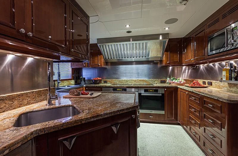 a kitchen with wooden cabinets aboard DOMANI Yacht for Sale
