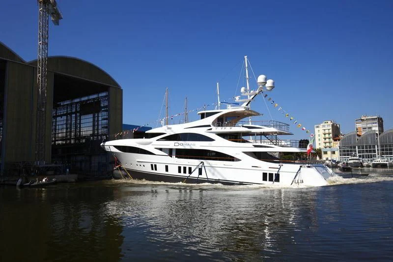 a white boat docked at a pier aboard DOMANI Yacht for Sale