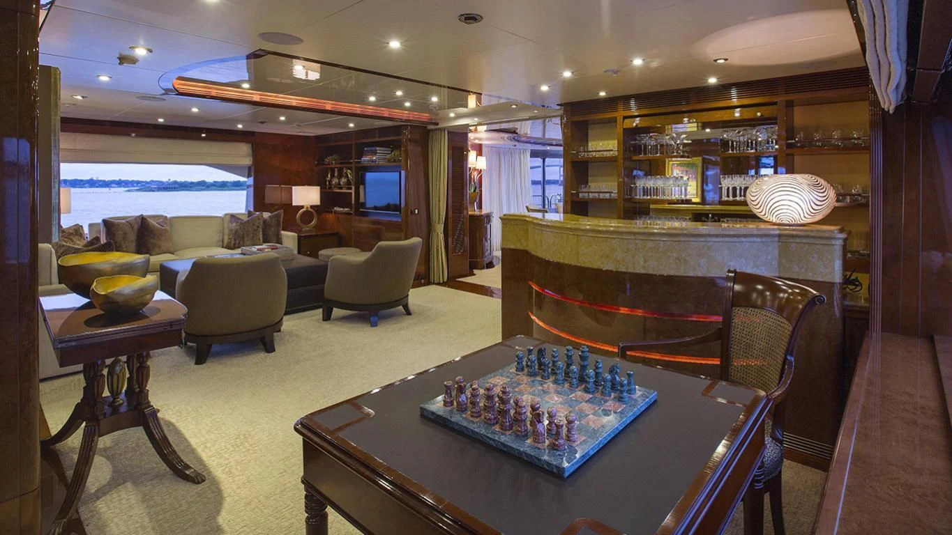 a living room with a large table and chairs aboard DOMANI Yacht for Sale