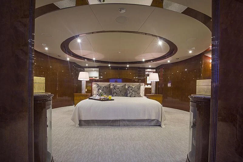 a large bedroom with a large chandelier aboard DOMANI Yacht for Sale