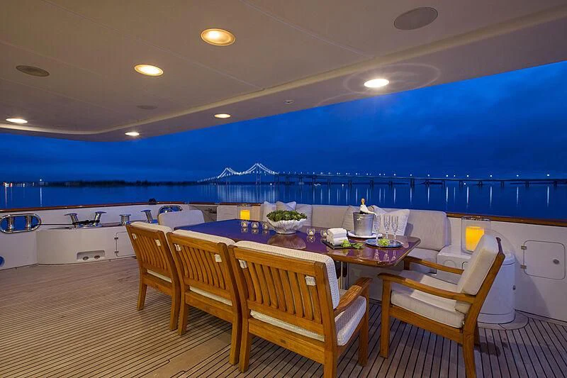 a large room with a table and chairs and a large body of water aboard DOMANI Yacht for Sale