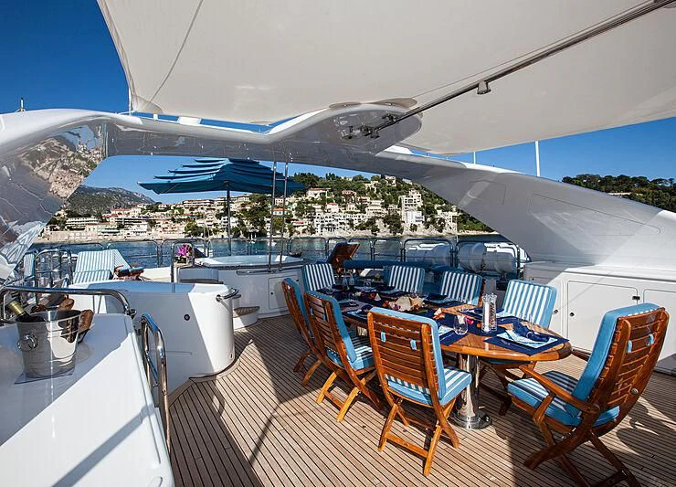 a deck with a large building and a pool aboard DOMANI Yacht for Sale