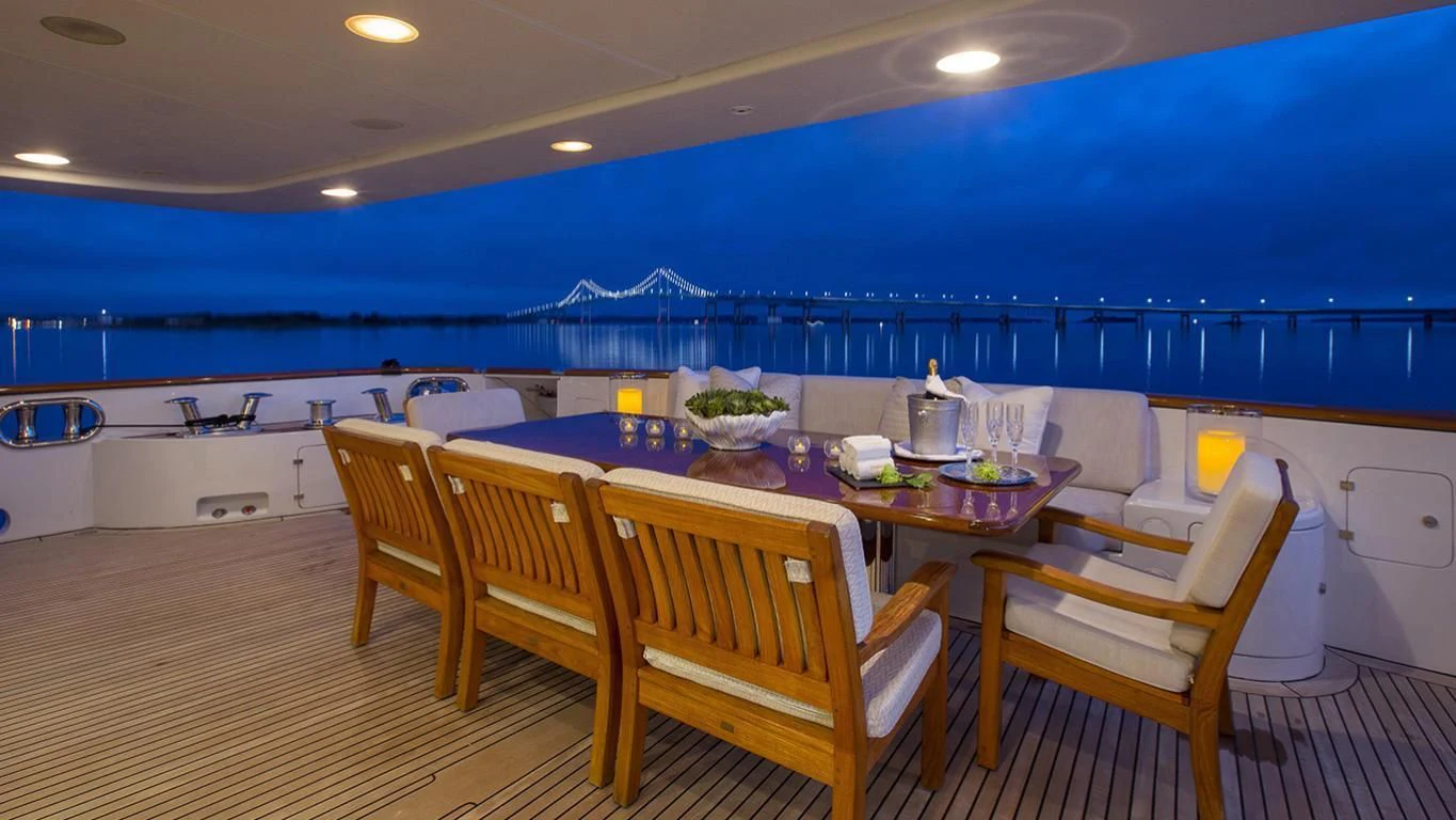 a large room with a table and chairs and a large blue ocean aboard DOMANI Yacht for Sale