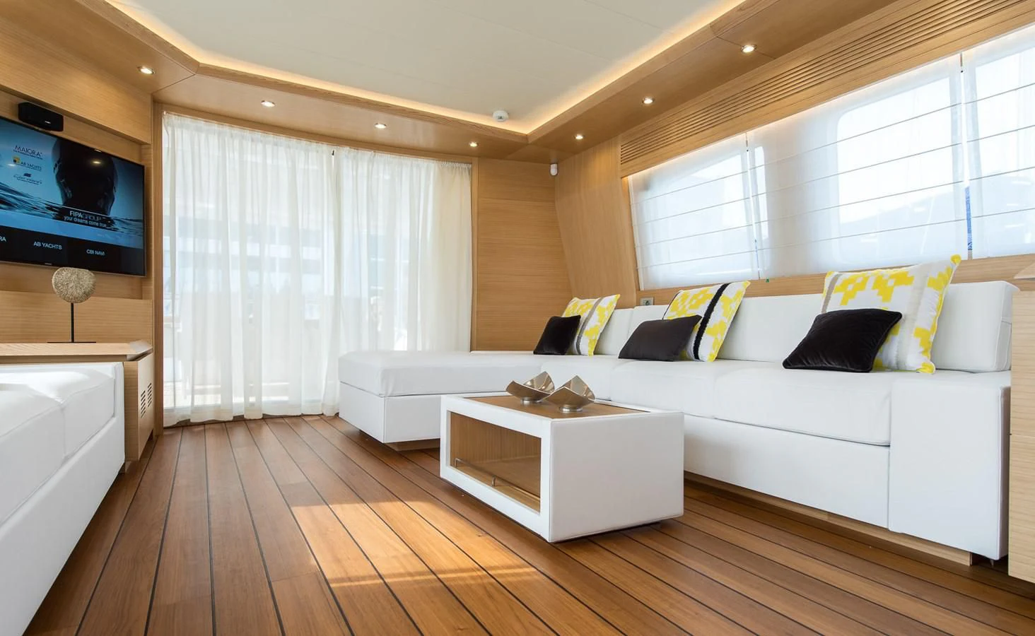 a living room with a large white couch and a television aboard MIREDO Yacht for Sale