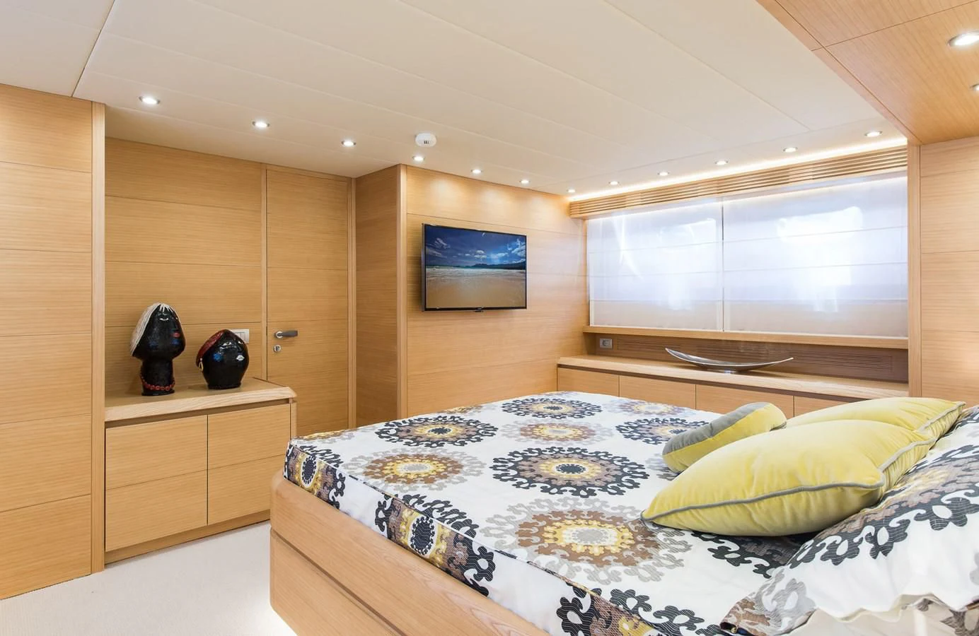 a bedroom with a bed and a wood cabinet aboard MIREDO Yacht for Sale
