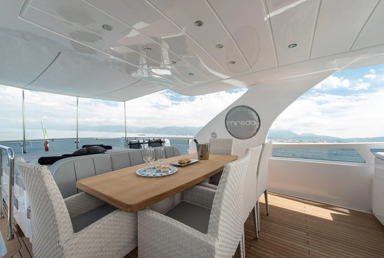 a room with a table chairs and a view of the ocean aboard MIREDO Yacht for Sale