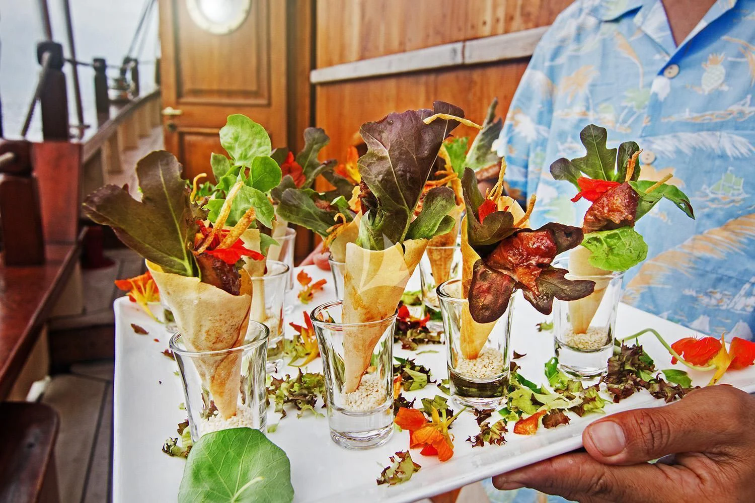 a hand holding a tray of food aboard MUTIARA LAUT Yacht for Sale