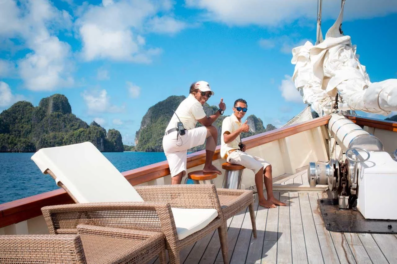a couple of men sitting on a boat on the water aboard MUTIARA LAUT Yacht for Sale