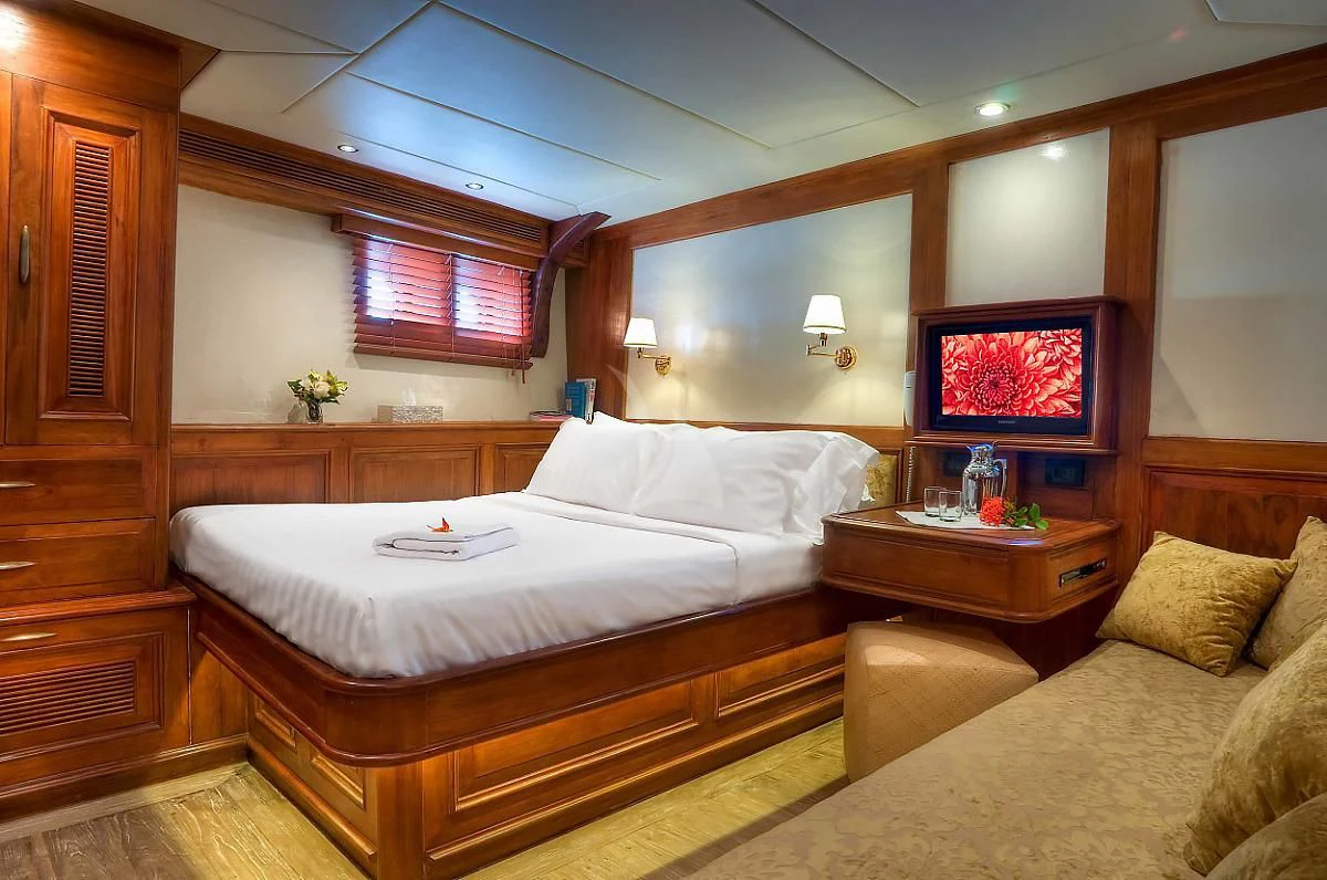 a room with a bed and a television aboard MUTIARA LAUT Yacht for Sale