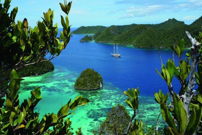 a body of water with a boat in it and a sailboat in the distance aboard MUTIARA LAUT Yacht for Sale