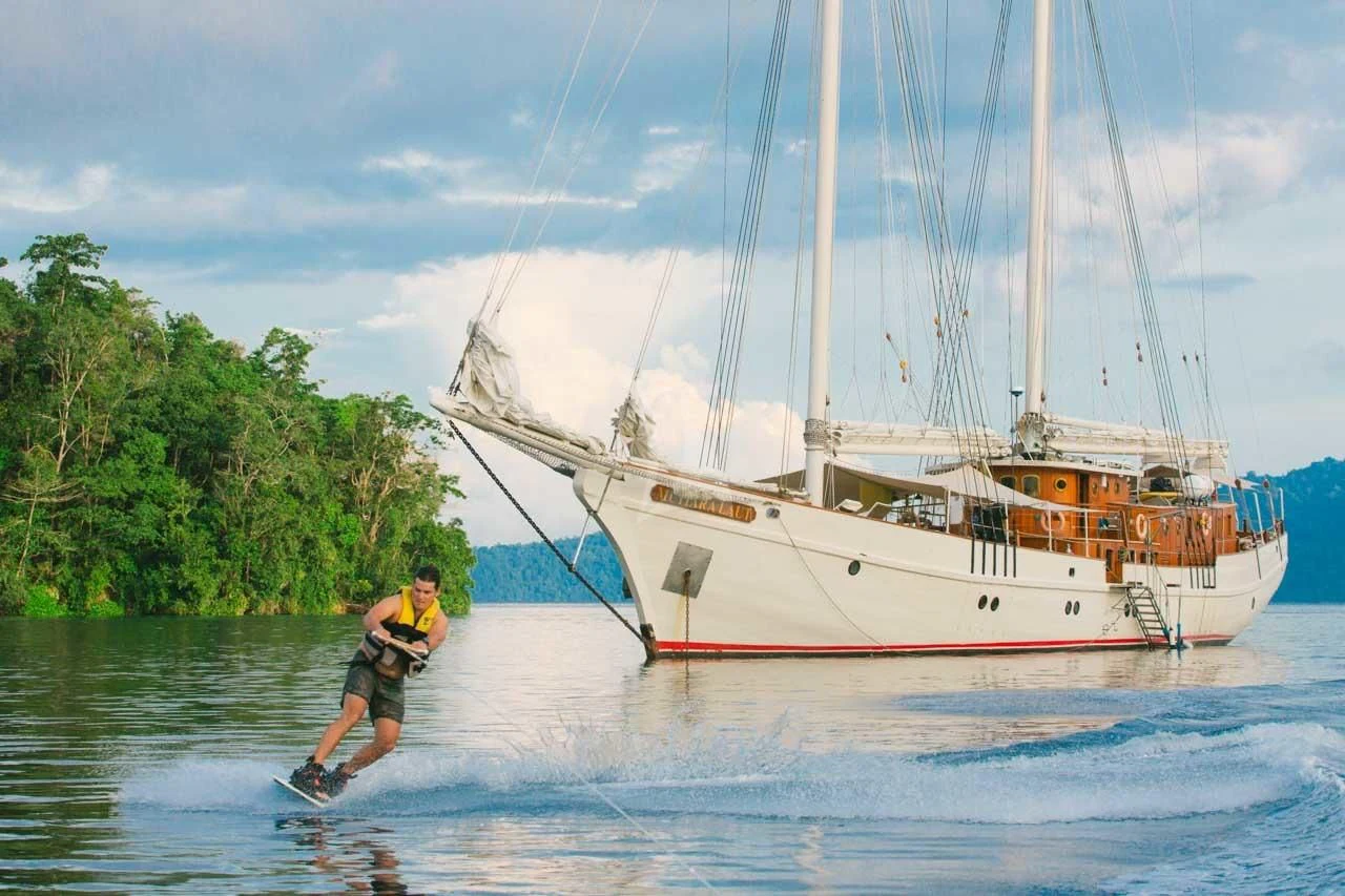 a person water skiing next to a boat aboard MUTIARA LAUT Yacht for Sale