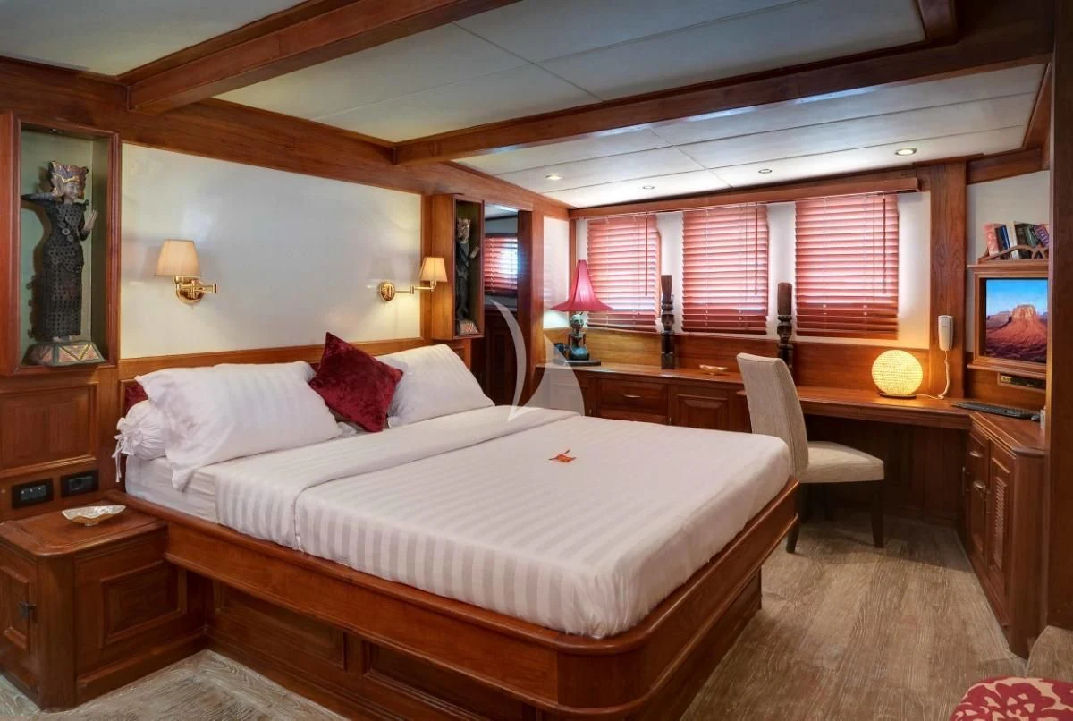a bedroom with a bed and desk aboard MUTIARA LAUT Yacht for Sale