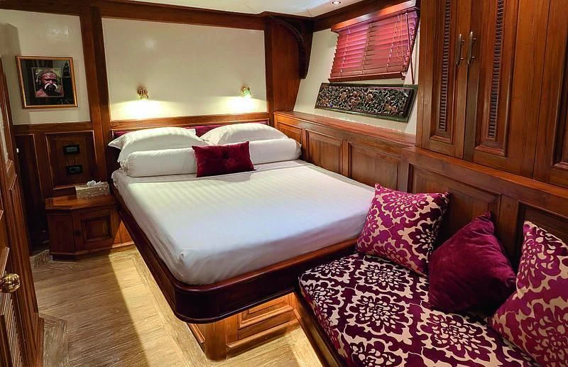 a bed with a purple blanket aboard MUTIARA LAUT Yacht for Sale