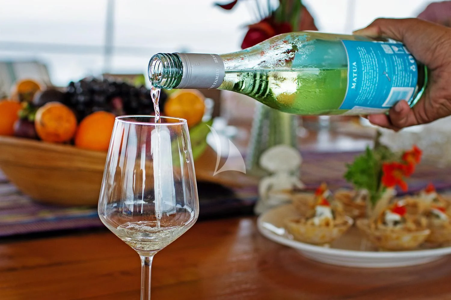 a person pouring wine into a glass aboard MUTIARA LAUT Yacht for Sale