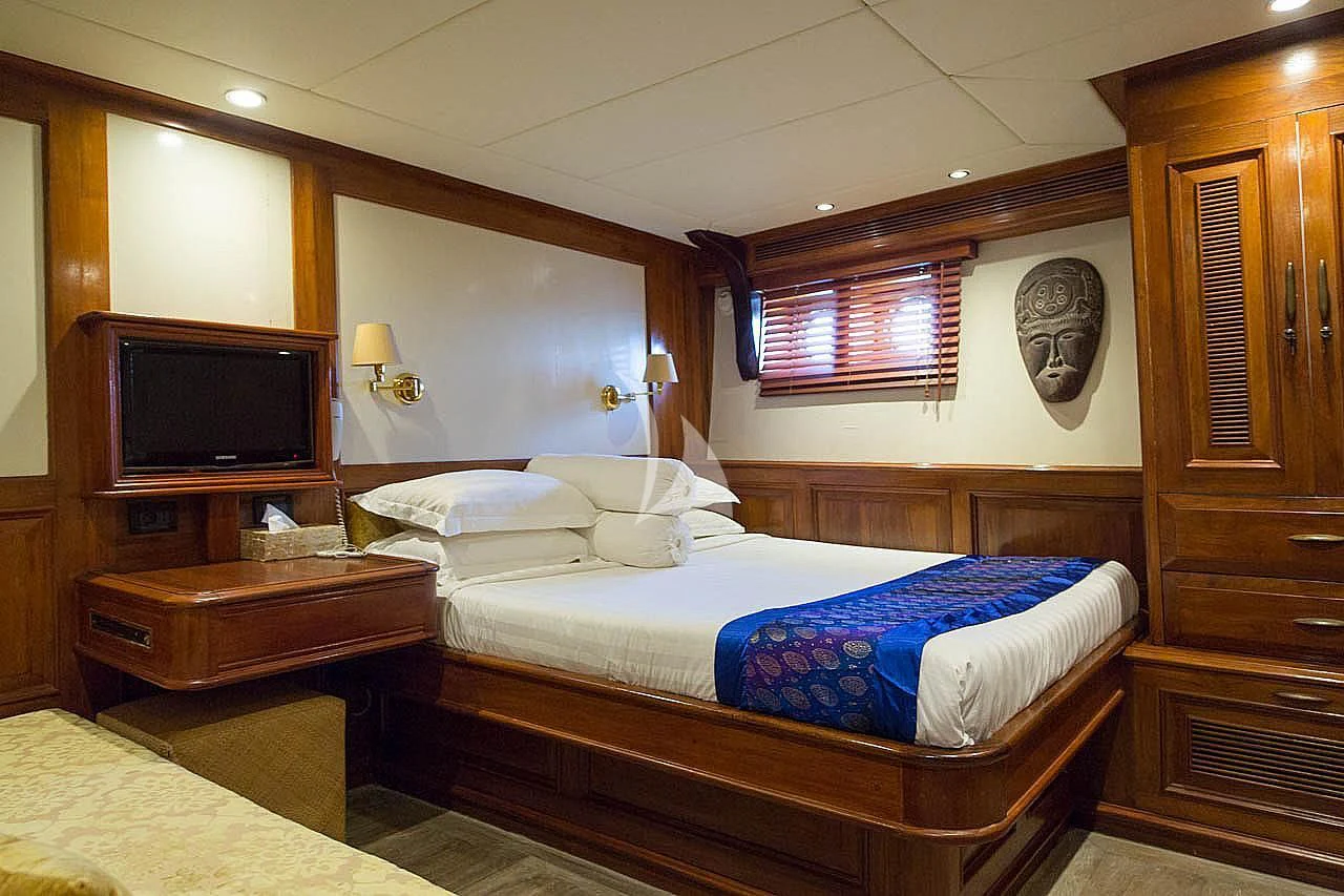a room with a bed and a television aboard MUTIARA LAUT Yacht for Sale