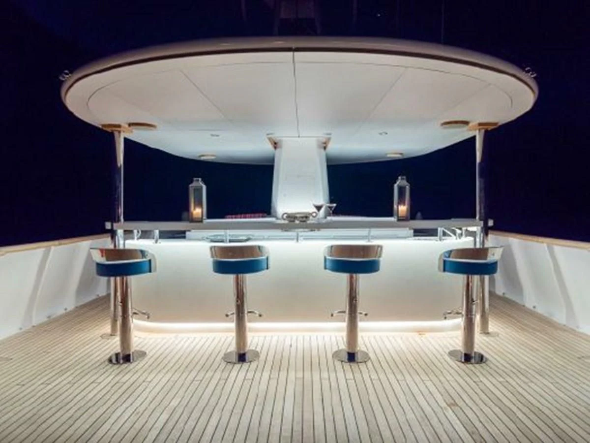 a table with stools and a lamp on it aboard CHARISMA Yacht for Sale