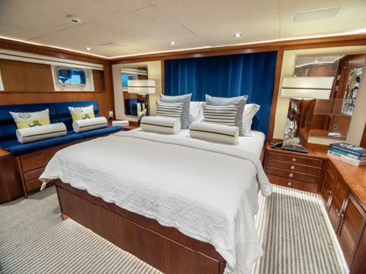a bedroom with a bed and a blue and white striped bed aboard CHARISMA Yacht for Sale