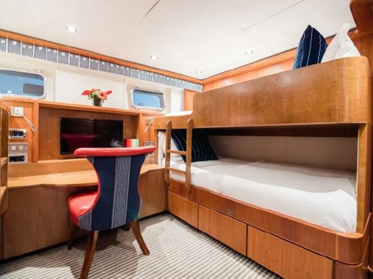 a bedroom with a bed and a chair aboard CHARISMA Yacht for Sale
