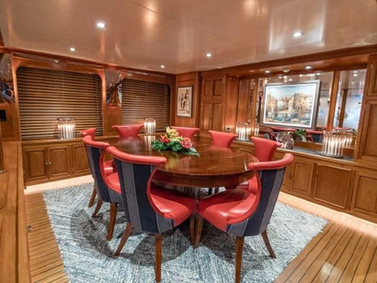 a dining room with red chairs aboard CHARISMA Yacht for Sale
