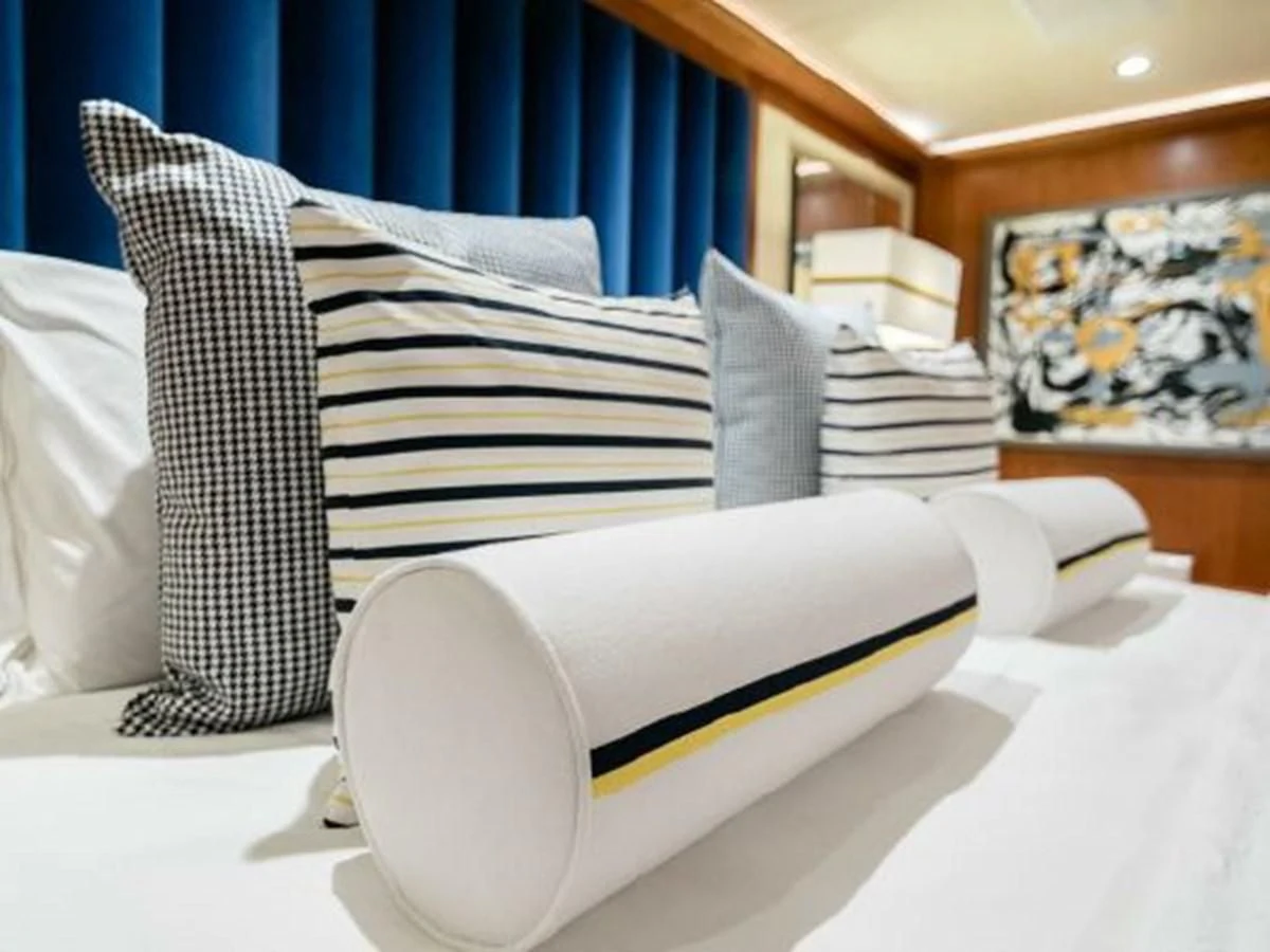 a white chair with a white pillow and a blue curtain aboard CHARISMA Yacht for Sale