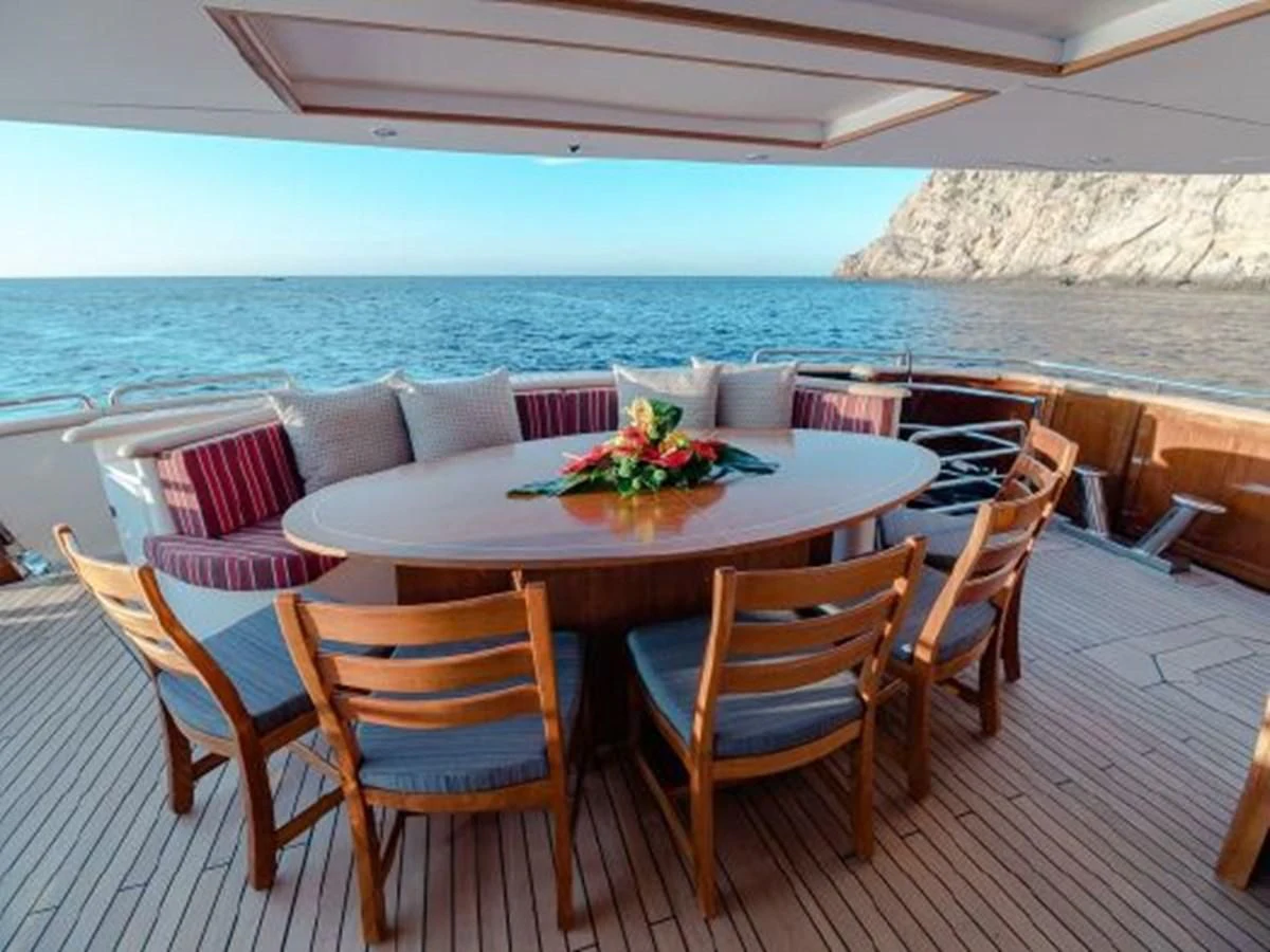 a table and chairs on a patio aboard CHARISMA Yacht for Sale