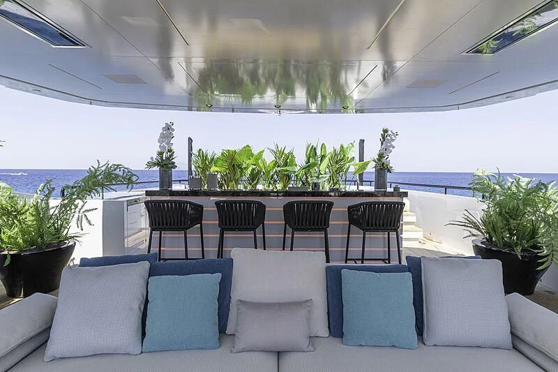 a large room with chairs and plants aboard LEL Yacht for Sale
