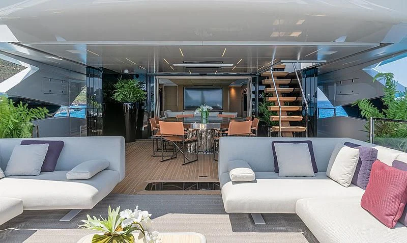 a living room with a staircase and a glass wall aboard LEL Yacht for Sale