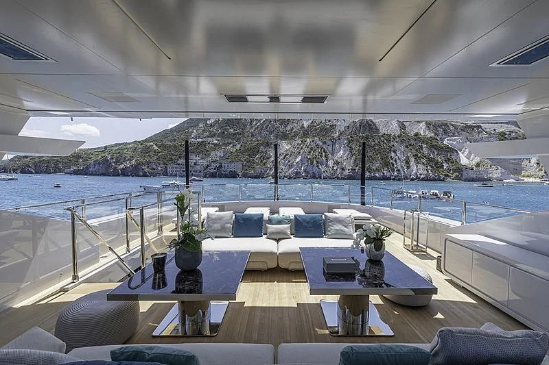 a room with a table and chairs on it by a body of water aboard LEL Yacht for Sale