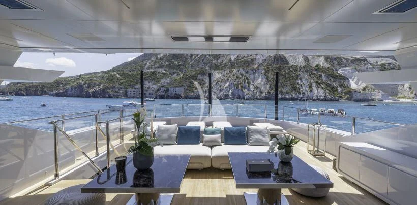a table on a balcony overlooking a body of water aboard LEL Yacht for Sale